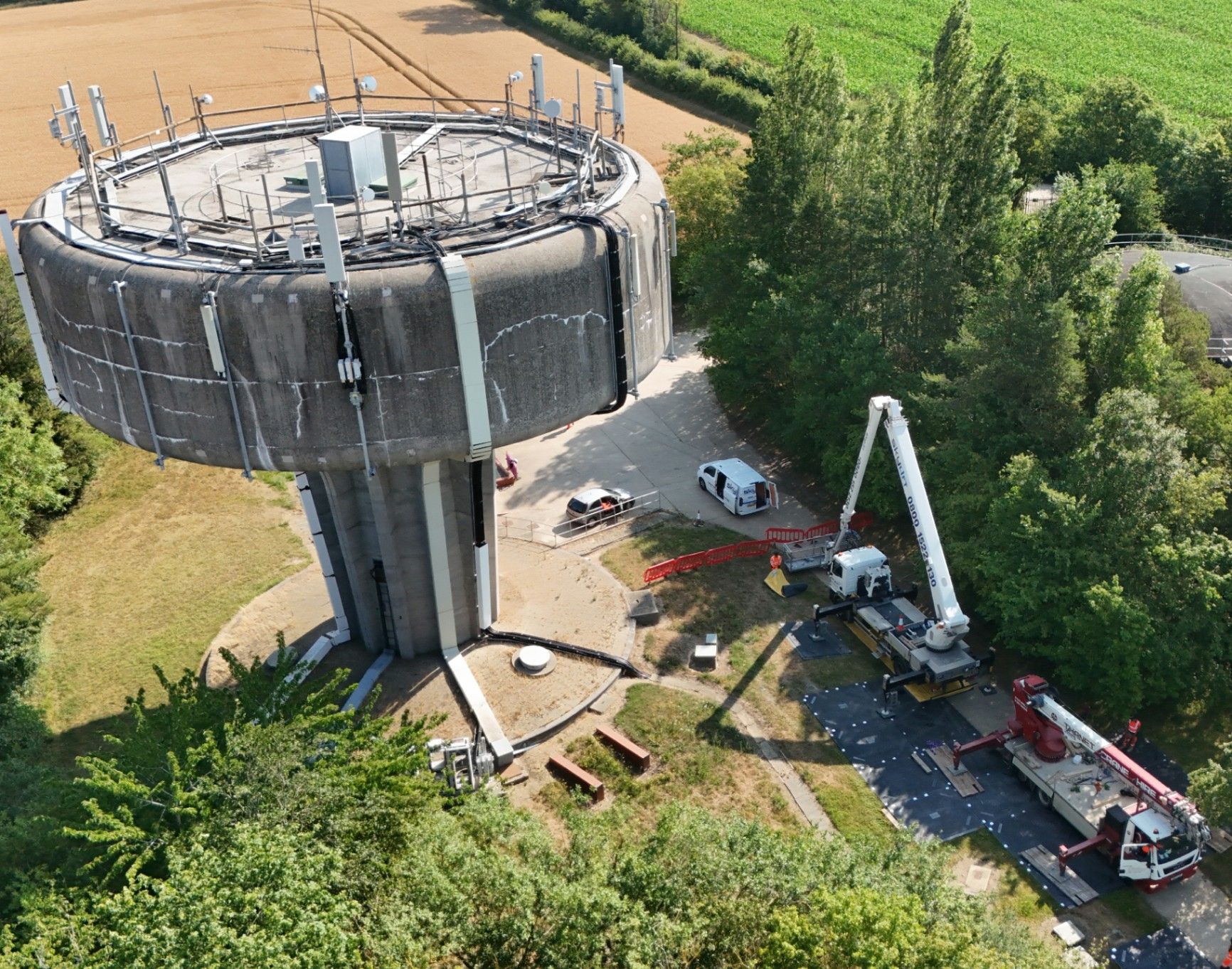 Aerial view of water tower infrastructure works with mobile lifting equipment